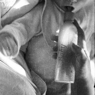 Black and white image of a baby being held.