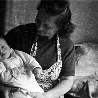 Woman holding a baby in a vintage black and white photograph.