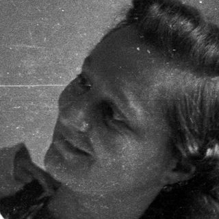 A woman holds a baby in a black and white photo.