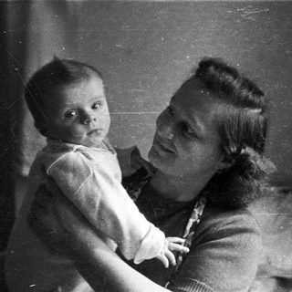 A woman holds a baby in a black and white photo.