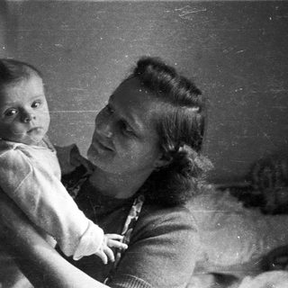 A woman holds a baby in a black and white photo.