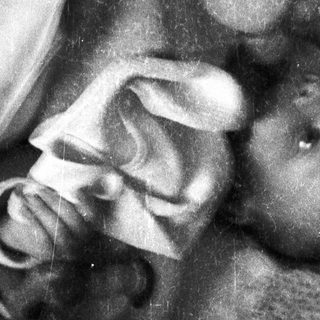 Black and white photo of a baby in a blanket.