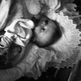 Black and white photo of a baby in a blanket.