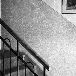 Staircase with railing and framed pictures on the wall.