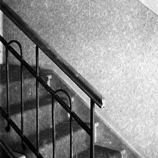 Staircase with railing and framed pictures on the wall.