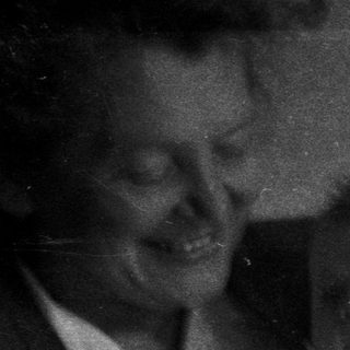 A person holding a baby in a monochrome photograph.