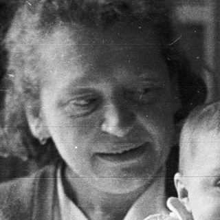 A person holds a baby in a black and white photo.