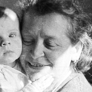Woman holding a baby in a black and white photograph.