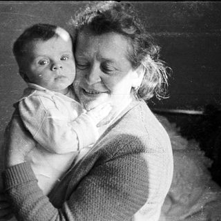 Woman holding a baby in a black and white photograph.