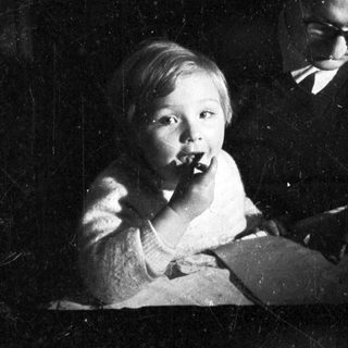 Baby and man seated, engaged in a moment together.