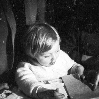 Baby and man seated, engaged in a moment together.