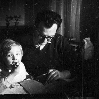 Baby and man seated, engaged in a moment together.