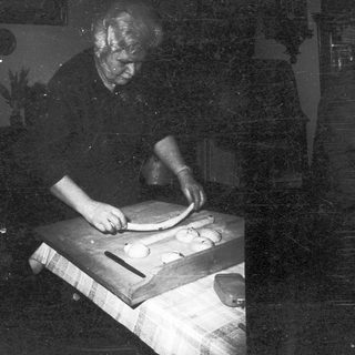 Man preparing dough on a wooden table.