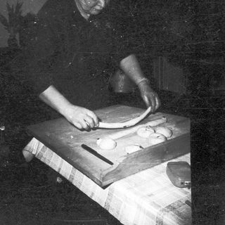 Man preparing dough on a wooden table.
