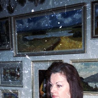 Woman in kimono stands in a room with artwork.