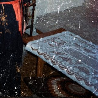 Woman in a kimono stands in a room with art.