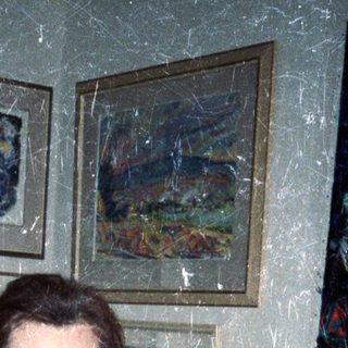 Woman in a kimono stands in a room with art.