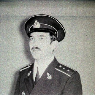 Man in military uniform and peaked cap is pictured.