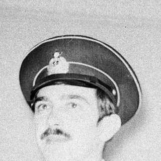 Man in military uniform, mustache, looking off to the side.