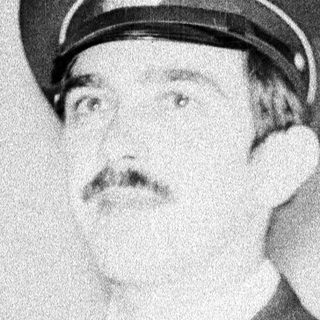Man in military uniform, mustache, looking off to the side.