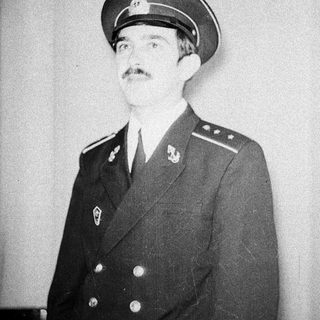 Man in military uniform, mustache, looking off to the side.