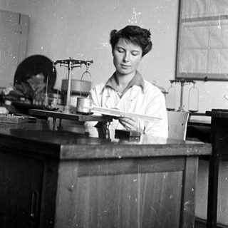 Woman working in a lab, using a scale.
