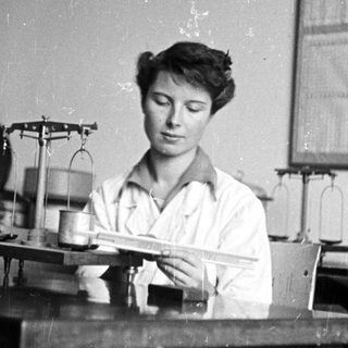 Woman working in a lab, using a scale.