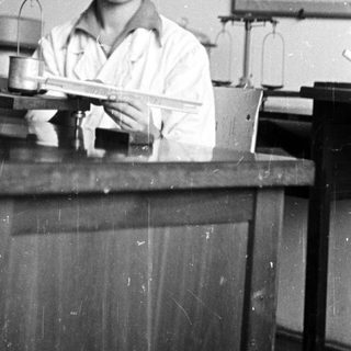 Woman working in a lab, using a scale.