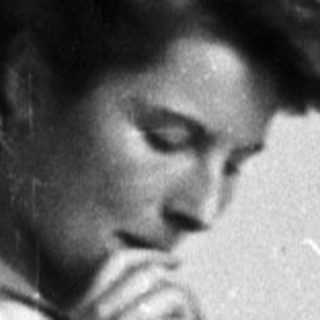 Woman in lab coat holds flask in a laboratory.