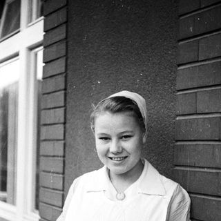 Young woman in a nurse's uniform smiles for a portrait.