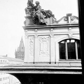 Black and white photo of building with statue and ornate details.