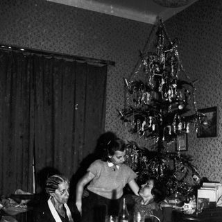 Family gathered around a table, decorated for Christmas.