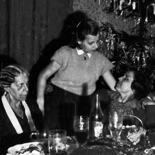 Family gathered around a table, decorated for Christmas.