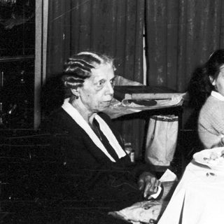 Family seated at a table with a Christmas tree.