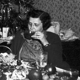 Family seated at a table with a Christmas tree.