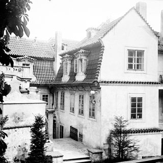 Here's a brief summary of the image: Historic building with tiled roof and connecting walkway.
