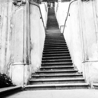 Monumental staircase ascends to an ornate, arched structure.