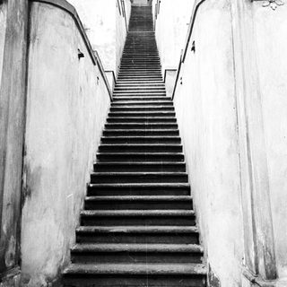 Black and white image of stone steps leading upwards.