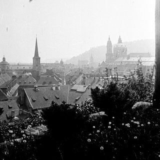 Black and white photo of a city skyline with rooftops.