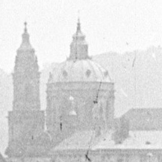 Black and white photo of a city skyline with rooftops.