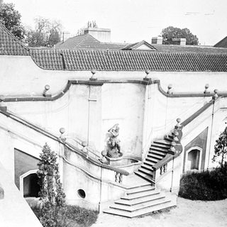 Ornate stone staircase leads down against a building facade.