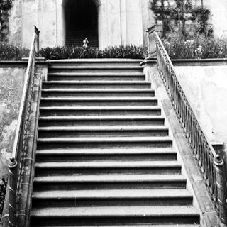 Stone staircase leads to an arched entrance and hillside.