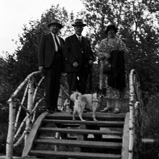 Group portrait on stairs with a dog and foliage.