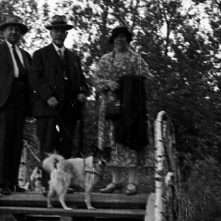 Group portrait on stairs with a dog and foliage.
