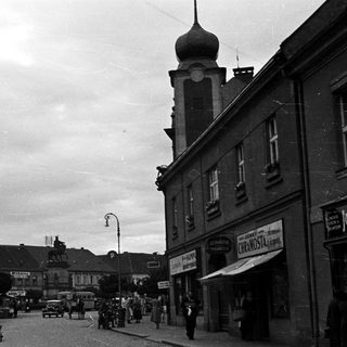 Black and white street scene with a statue and buildings.