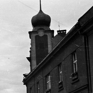 Black and white street scene with a statue and buildings.