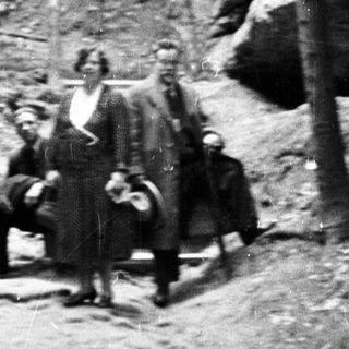 People standing in a rocky, forested, outdoor setting.