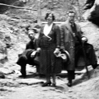 People standing in a rocky, forested, outdoor setting.