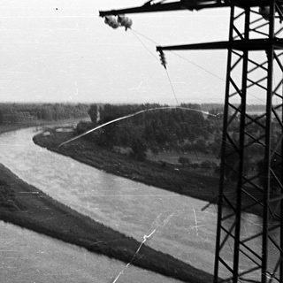 River flows beneath power lines in a landscape.