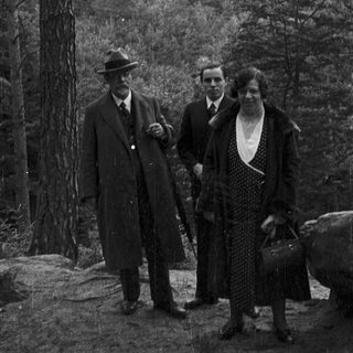 Three people stand before a castle, likely on a trip.